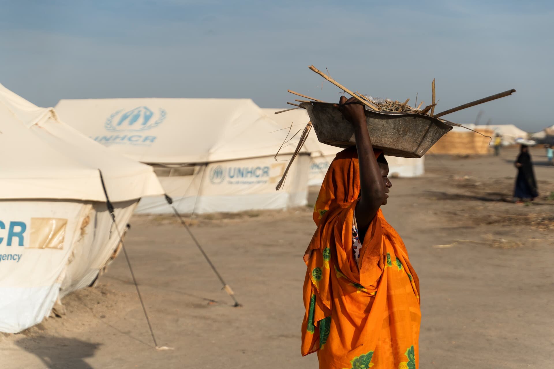 Une femme transporte du bois de chauffage dans le camp de Khor Ajwal pour les déplacés internes, dans l’État soudanais du Nil Blanc. ©HCR/Ala Kheir