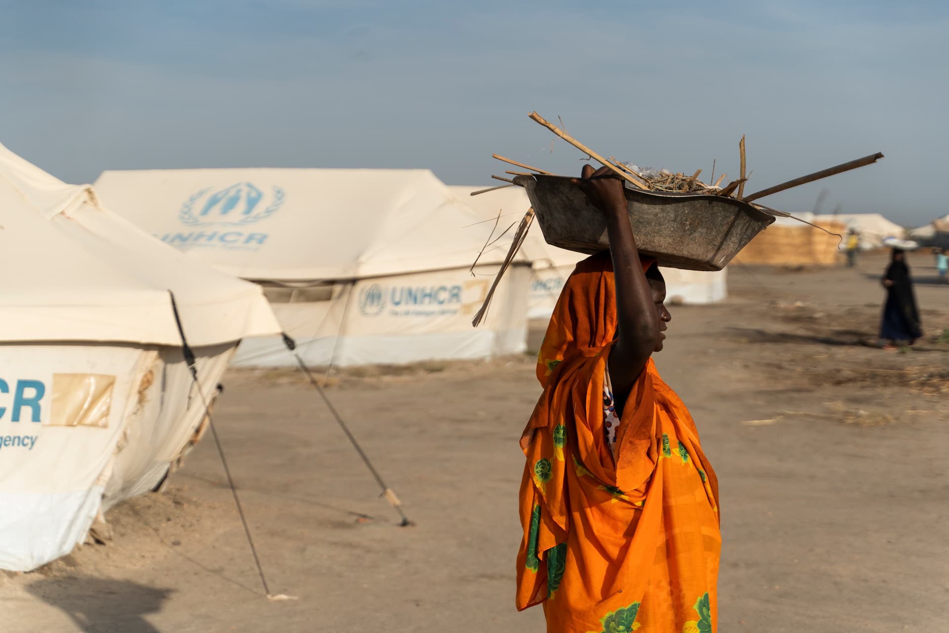 A woman carries firewood in Khor Ajwal camp for internally displaced people in Sudan’s White Nile State.